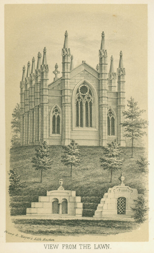 Stone chapel with spires and vertical windows on a grassy hill in a cemetery landscape with two hillside tombs and small trees.